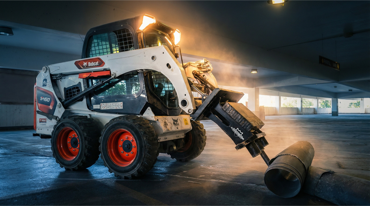 Bobcat skid-steer loader in a warehouse setting with bright lights.